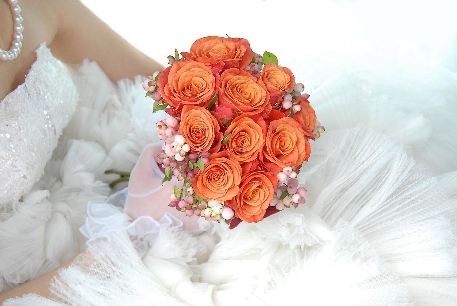 Weddings in and Around Paris 57 Orange wedding bouquet held by bride in dress and pearl necklace