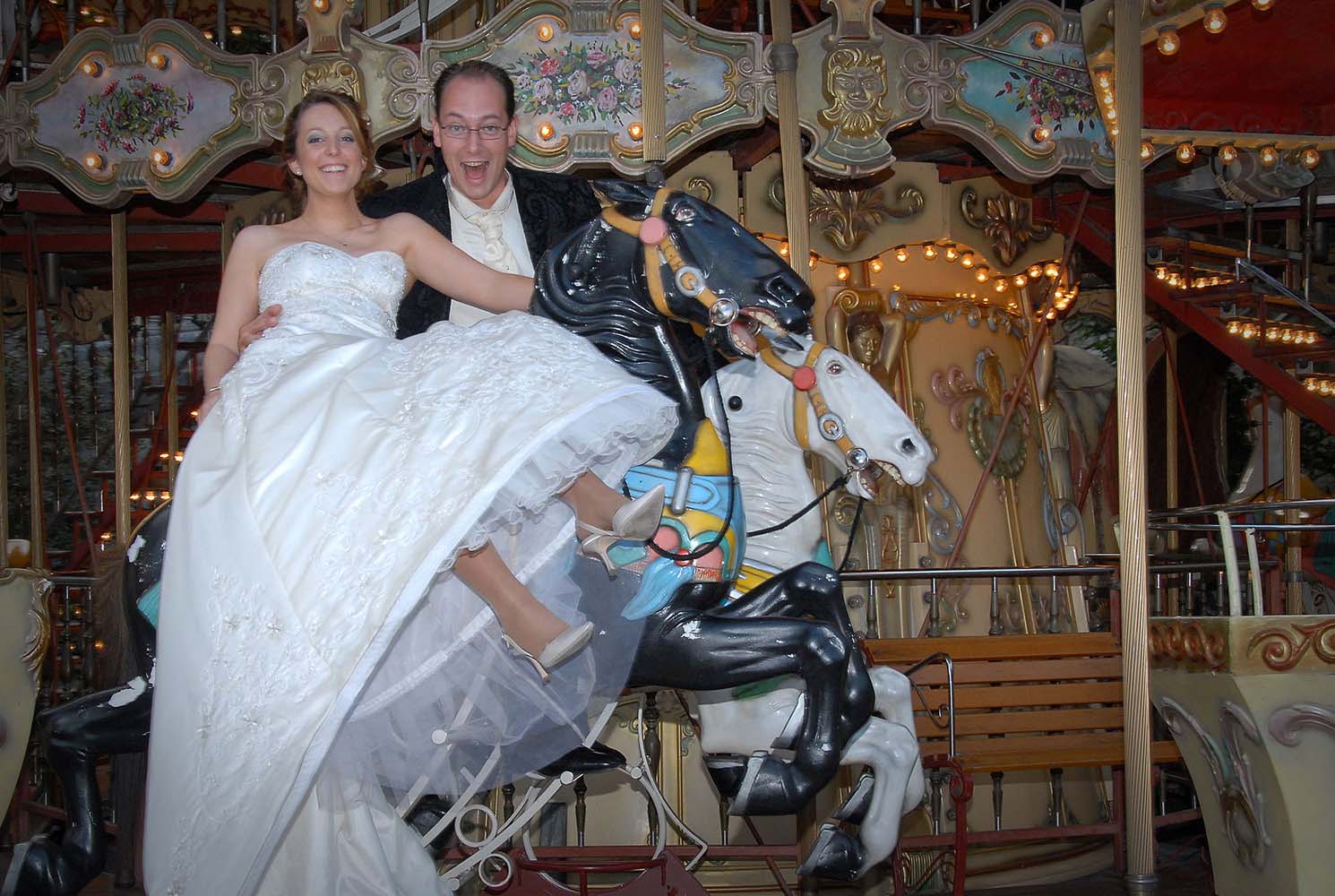 Weddings in and Around Paris 27 Groom and bride in wedding dress on merry go round, Paris, France