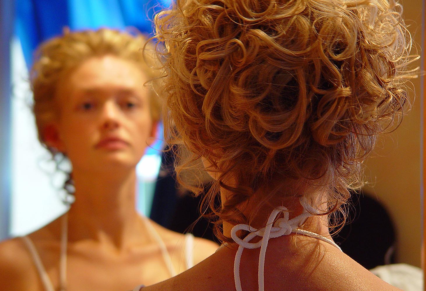Bride in front of mirror after hairstyling