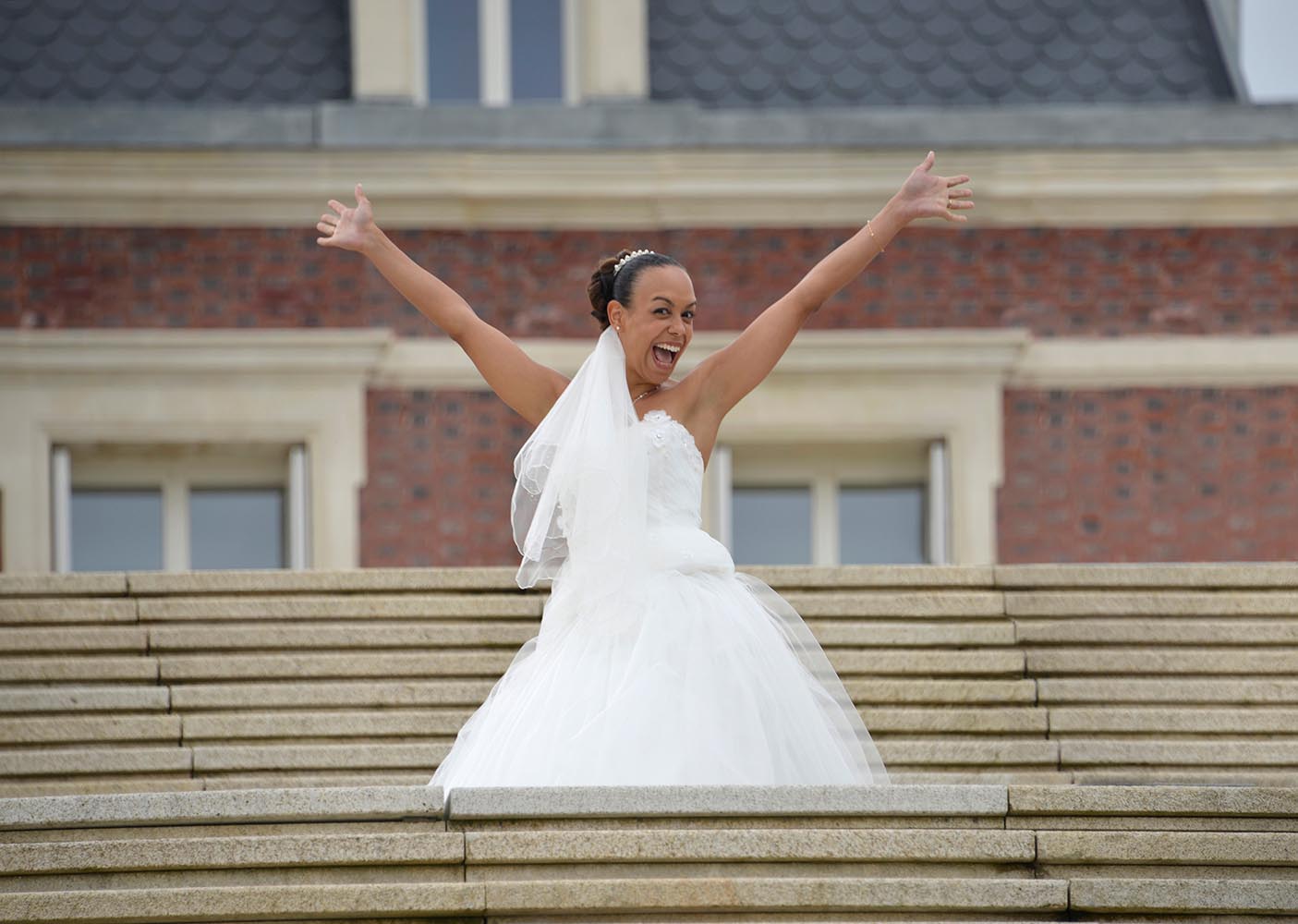 Happy Bride in wedding dress showing her happiness with hands up