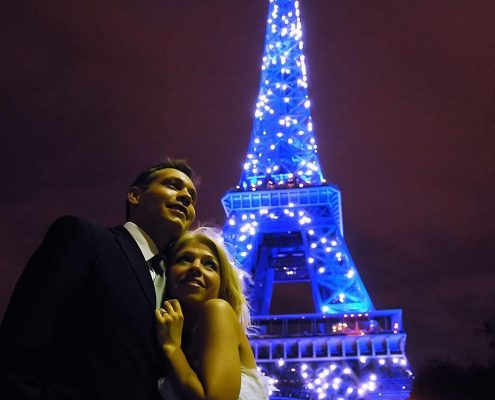 Couple de maries devant la Tour Eiffel bleue et etincellant, Paris