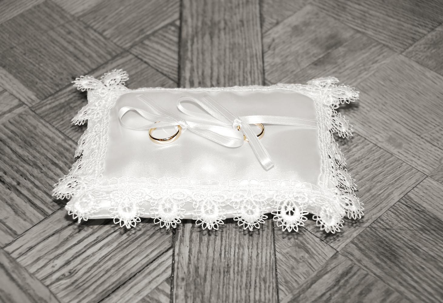 Wedding rings on a laced cushion