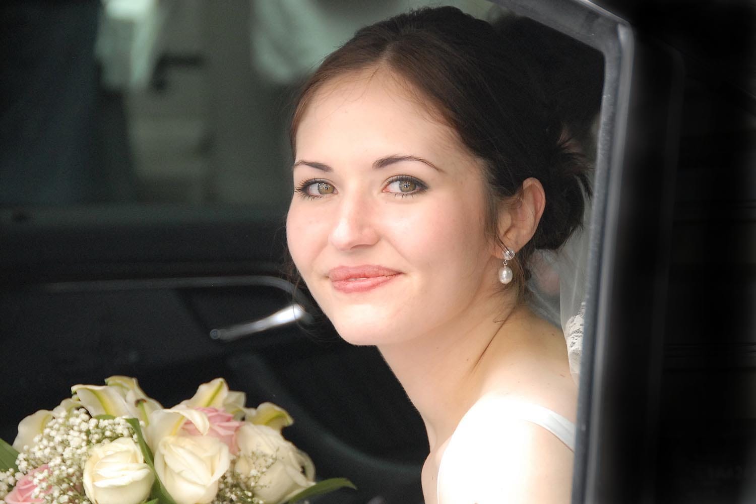 Weddings in and Around Paris 71 Portrait of bride holding a bouquet of flowers in limousine