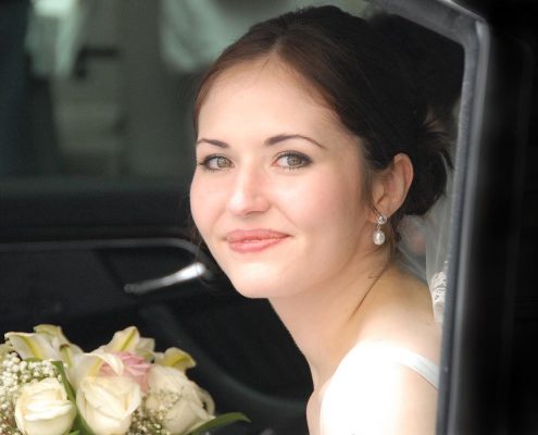 Portrait mariee avec bouquet de mariage dans voiture de prestige