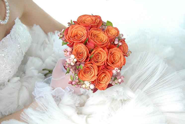 Bouquet de mariage orange sur robe de mariee - Photo Haig Photographe Paris